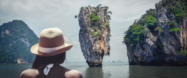 Person staring out at a rock island in the water