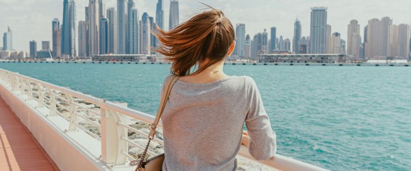 Young woman looking over the river at a city