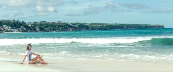 Person staring out to see while relaxing on a beach